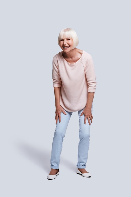 Insouciant. Toute la longueur de la belle femme âgée regardant loin et souriant