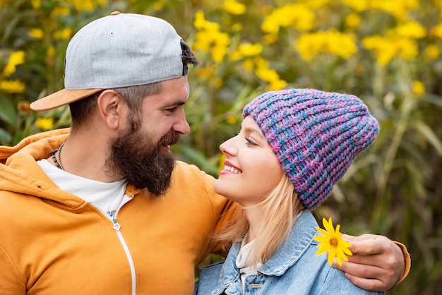 Insouciante jeune femme avec bel homme barbu en pull vintage branché