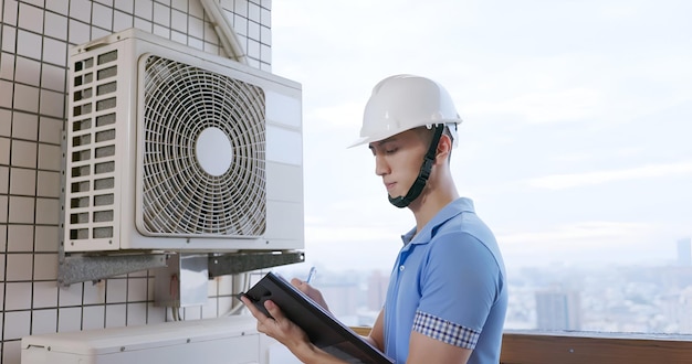 L'inspecteur de la maison vérifie le climatiseur.