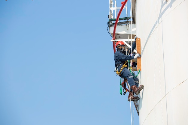 Photo inspection de l'accès par corde des travailleurs masculins de l'industrie des réservoirs de stockage d'épaisseur