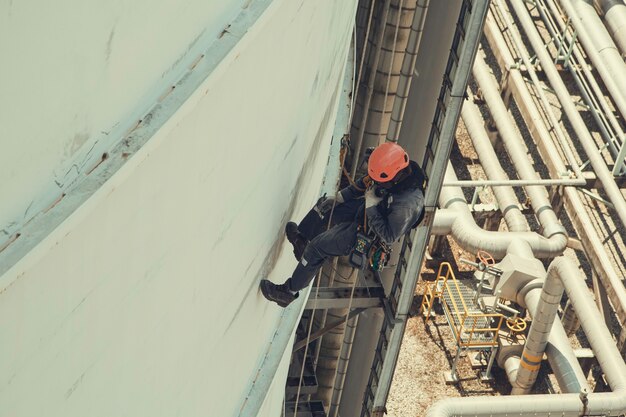 Inspection de sécurité de la hauteur d'accès par corde des travailleurs masculins de l'industrie des réservoirs de pétrole et de gaz de stockage d'épaisseur