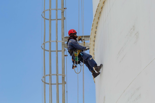 Inspection de sécurité de la hauteur d'accès par corde des travailleurs masculins de l'industrie des réservoirs de pétrole et de gaz de stockage d'épaisseur