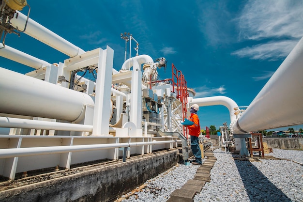 Inspection des travailleurs masculins sur les longs tuyaux en acier et le coude du tuyau dans l'usine pétrolière de la station pendant la vanne de la raffinerie de l'enregistrement de contrôle visuel