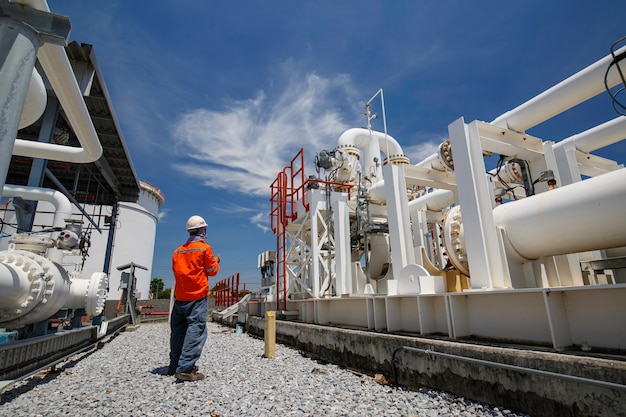 Inspection des travailleurs masculins sur les longs tuyaux en acier et le coude du tuyau dans l'usine pétrolière de la station pendant la vanne de la raffinerie de l'enregistrement de contrôle visuel