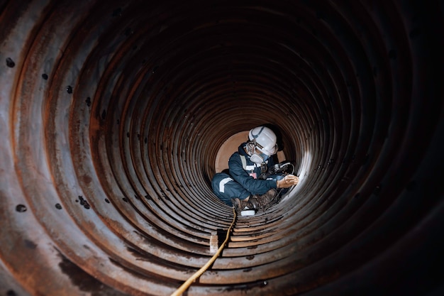 L'inspection Des Travailleurs Masculins A Mesuré L'épaisseur Circulaire Du Tuyau De Serpentin De L'épaisseur Minimale De Balayage De La Chaudière Dans Un Espace Confiné Dangereux.