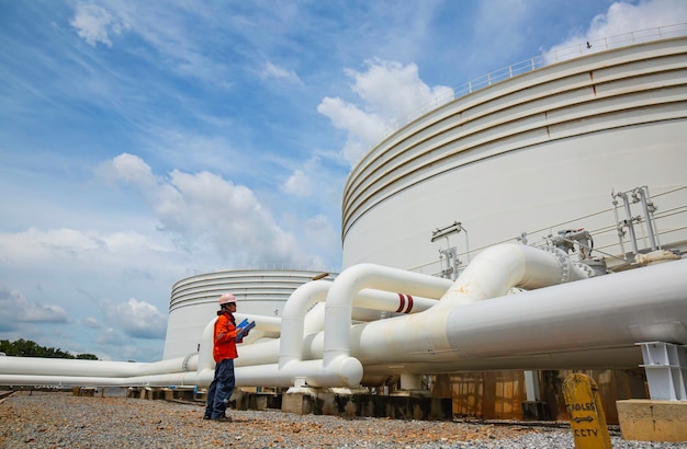 Inspection des travailleurs de sexe masculin dans les longs tuyaux en acier et le coude de tuyau dans l'usine de pétrole de la station pendant la vanne de raffinerie de l'huile du réservoir de pipeline d'enregistrement de contrôle visuel