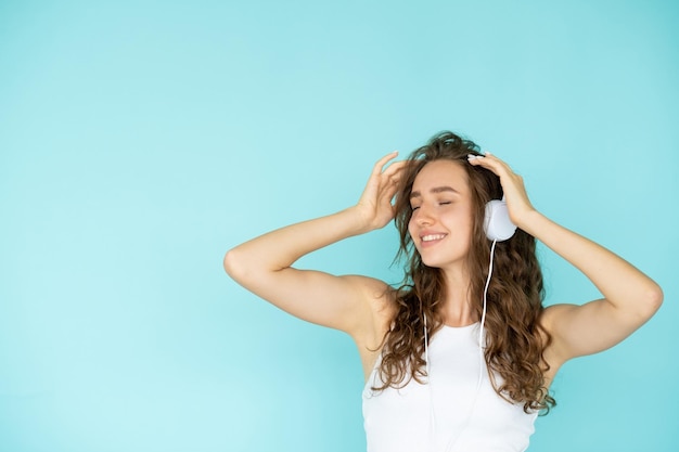 Inspiration musicale Femme heureuse Bon son Heureuse jolie dame dans un casque tenant les mains sur la tête se sentant joie espace de copie bleu isolé