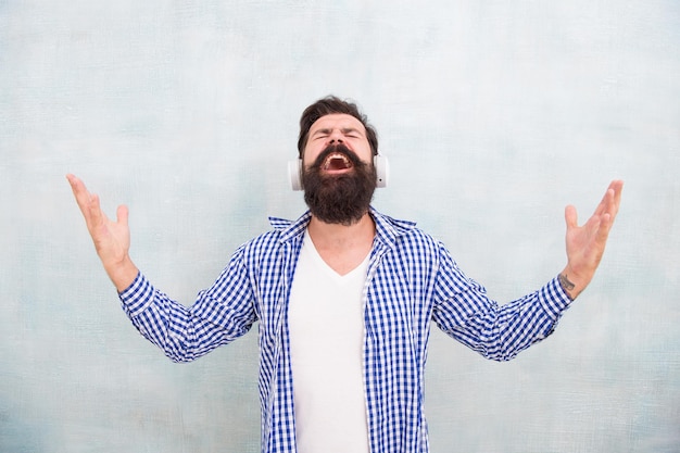 Inspiré par la qualité du son. écouter la liste de lecture en plein air. écoute de la musique dans des écouteurs sans fil. homme barbu heureux. l'homme apprécie sa chanson préférée. la musique c'est ma vie. homme hipster dans les écouteurs. se sentir libre.