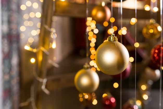 Installation d'art d'arbre de Noël faite avec des guirlandes lumineuses et des boules de Noël suspendues à des fils