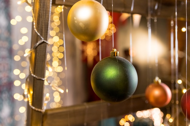 Installation d'art d'arbre de Noël faite avec des guirlandes lumineuses et des boules de Noël suspendues à des fils