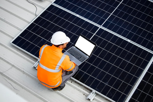 Installation d'une centrale solaire comme source d'énergie durable Ouvrier plaçant un panneau solaire sur le toit