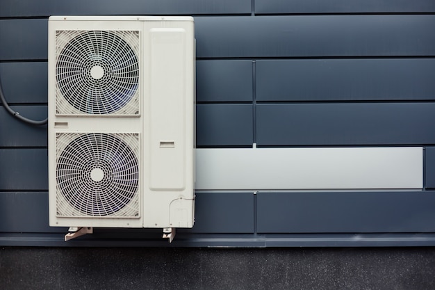 Installation de compresseur d'air sur un mur carrelé en métal d'un bâtiment moderne