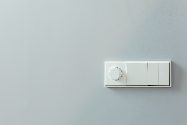 Photo installation d'interrupteurs et de commandes pour l'éclairage sur un mur blanc