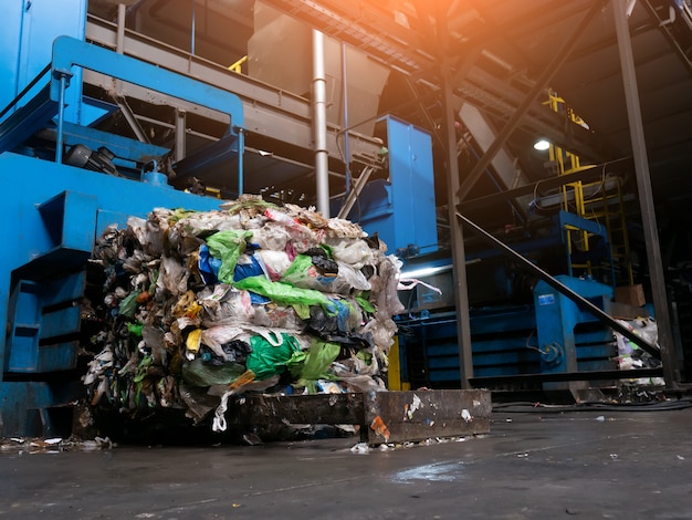 Installation moderne de tri et de recyclage des déchets, la presse hydraulique fabrique des balles câblées à partir de bouteilles PET pressées pour le traitement et la réutilisation du plastique. Concept de défense de l'environnement par le recyclage des matériaux.