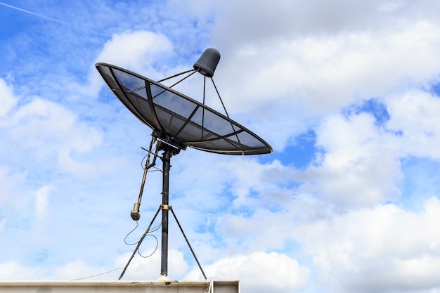 Installation par satellite noir sur le toit de la maison avec fond de ciel bleu