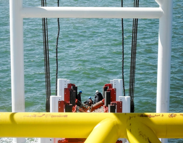 Photo installation de tuyaux avec une grue de barge à tuyaux près du rivage descente du pipeline jusqu'à un fond épuisant avec la barge à tubes installation du pipeline de gaz sous-marin