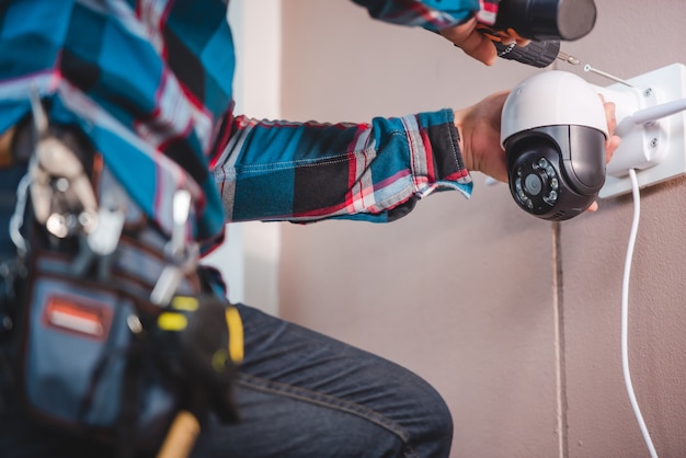 Installation de vidéosurveillance avec de jeunes techniciens asiatiques. Installation telle que la caméra IP Wifi Concept: caméra IP sans fil