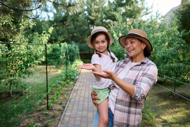 Instiller l'amour pour l'agriculture dès l'enfance Maman et sa fille tiennent un espace de copie sur les mains paumes vers le haut dans la ferme biologique familiale