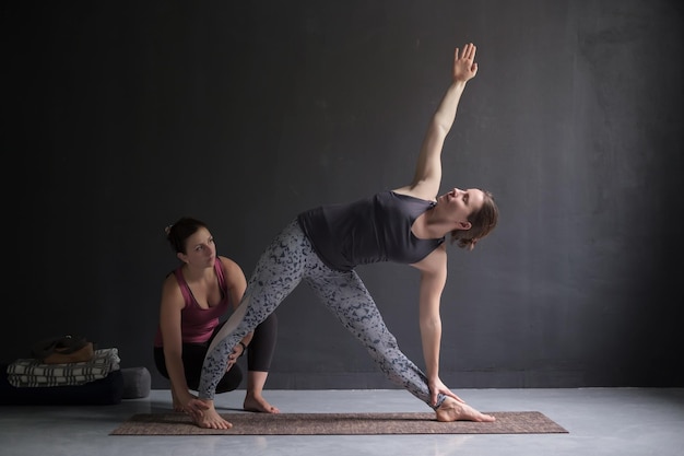 Instructeur de cours de yoga et débutant faisant des exercices d'asana