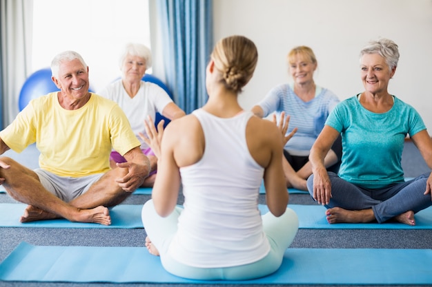 Instructeur effectuant du yoga avec des personnes âgées