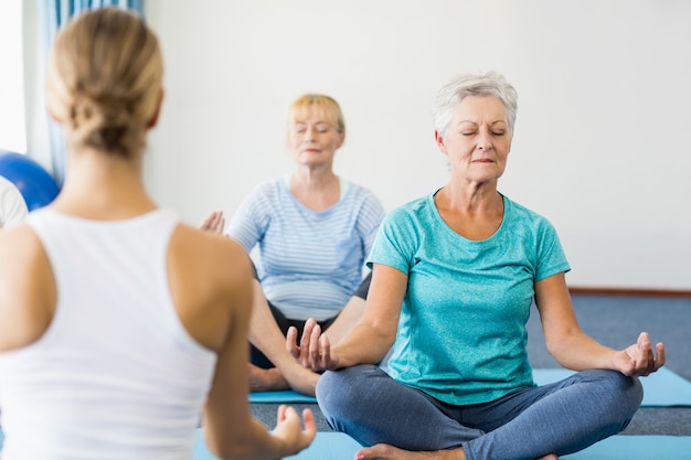 Instructeur effectuant du yoga avec des personnes âgées