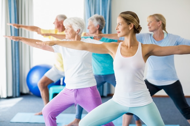 Instructeur effectuant du yoga avec des personnes âgées