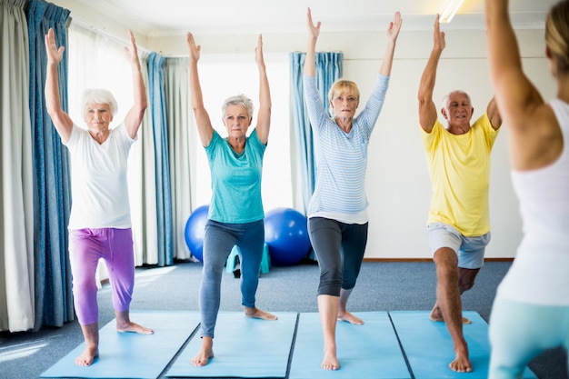 Instructeur effectuant du yoga avec des personnes âgées