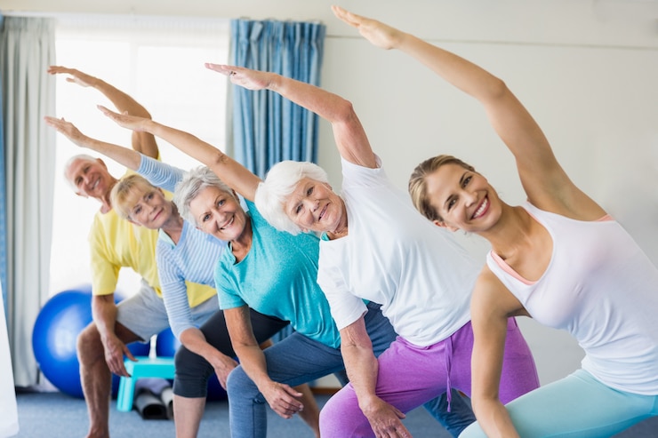 Photo instructeur effectuant du yoga avec des personnes âgées