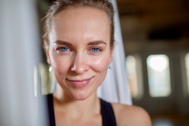 Instructeur en gros plan portrait de yoga aérien. Fille de hipster avec un formateur de yoga de regard expressif posant pour la caméra