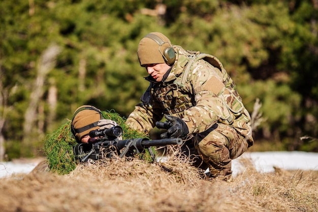 Instructeur avec opérateur visant une mitrailleuse sur le champ de tir Concept humain et militaire