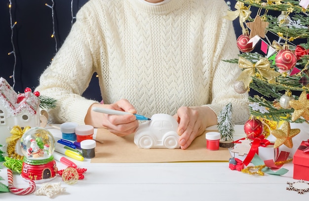 Instruction photo étape par étape d'un décor de Noël une fille peint une machine à plâtre étape 1 préparation