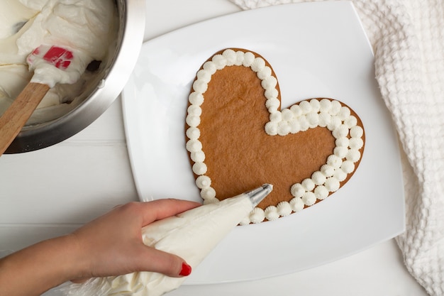 Instructions étape par étape de recette de gâteau en forme de cœur. Étape 10: Appliquez la crème sur les gâteaux à l'aide d'une poche à douille, à plat.