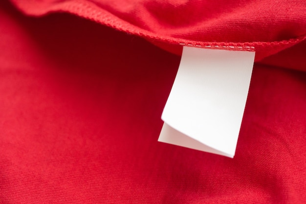 Instructions de lavage du linge blanc sur l'étiquette des vêtements sur chemise en coton rouge