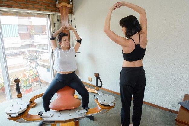 une instructrice d'exercices de réadaptation pour adultes entraînant son élève