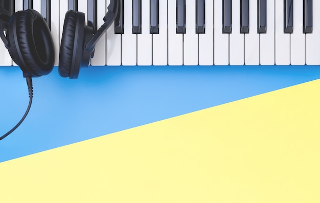 Instrument de clavier de musique avec un casque sur l&#39;espace de copie jaune bleu pour le concept de musique