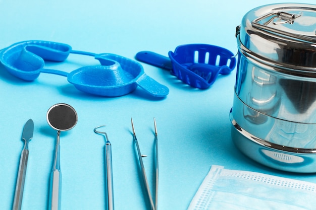 Instruments dentaires pour la dentisterie sur fond bleu clair
