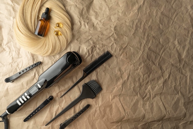 Instruments pour les procédures de soins capillaires de salon allongés sur un papier kraft brun