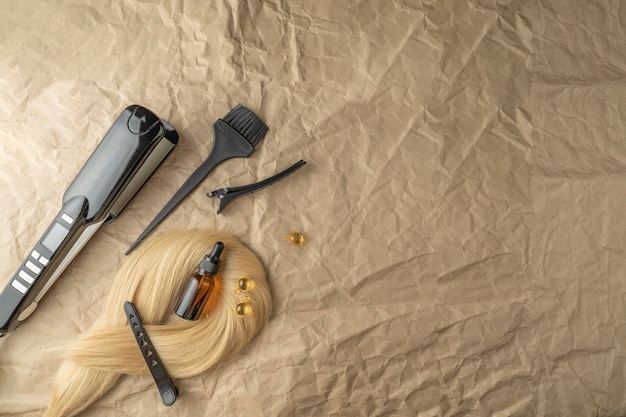 Instruments pour les procédures de soins capillaires de salon allongés sur un papier kraft brun