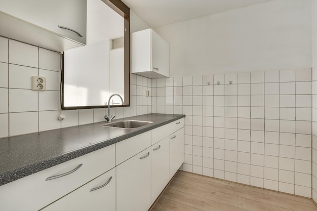 Un intérieur bien organisé d'une petite cuisine familiale avec un évier sous la fenêtre et des meubles clairs dans un appartement en ville