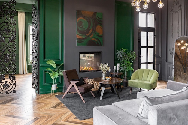 l'intérieur brutal du salon dans un style historique dans un manoir avec des fenêtres panoramiques murs gris-vert parquet brun et meubles modernes