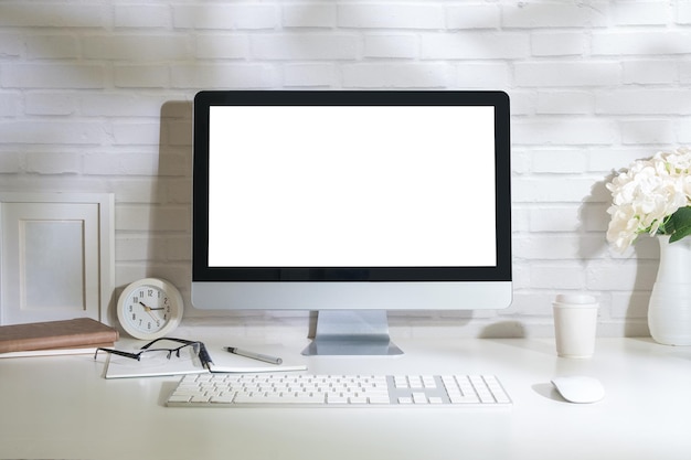 Intérieur de bureau à domicile avec écran d'ordinateur vierge et fournitures de bureau sur tableau blanc