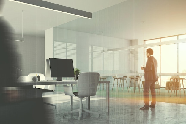 Intérieur d'un bureau moderne avec sol en béton et vert, fenêtres panoramiques et écrans d'ordinateur noirs sur les tables. Hommes d'affaires. Rendu 3D maquette image tonique double exposition floue