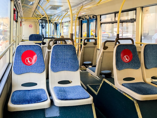 Intérieur d'un bus public vide avec des autocollants rouges sur les sièges sur le respect de la distance sociale