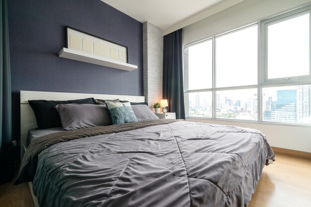 Intérieur chaleureux et confortable de l'espace de la chambre à coucher avec cadre d'affiche maquette de lit