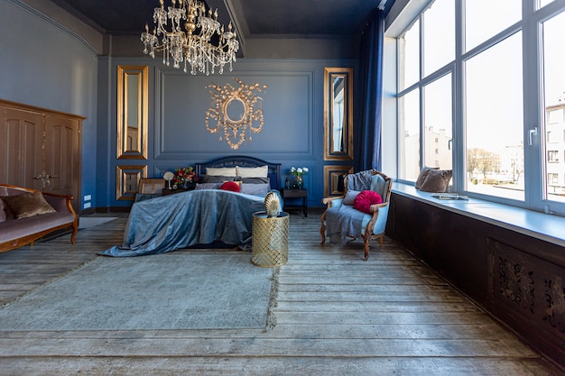 Intérieur de chambre à coucher chic de luxe de couleur bleu foncé avec des meubles anciens coûteux et des éléments en or de style baroque