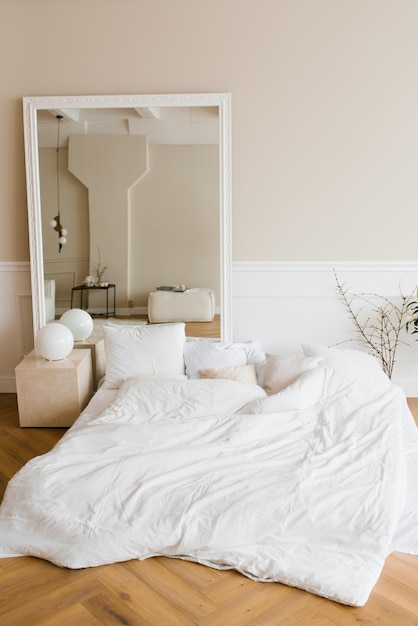 Intérieur de chambre à coucher de style scandinave Un lit au sol avec des draps blancs et des oreillers