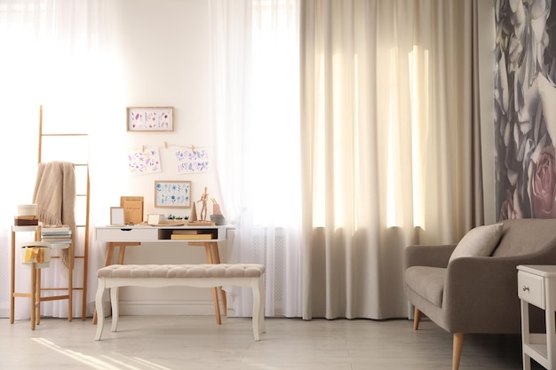 Intérieur de chambre élégant avec lieu de travail créatif près d'un mur blanc