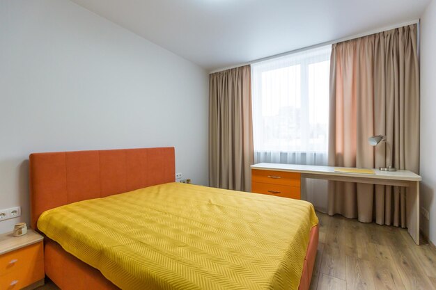 Intérieur d'une chambre avec un lit orange et un canapé dans un style moderne