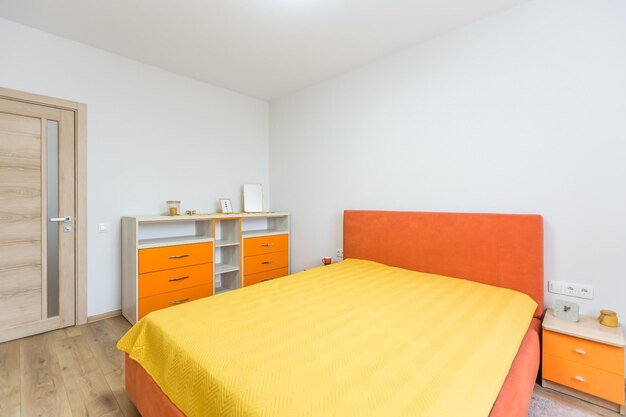 Intérieur d'une chambre avec un lit orange et un canapé dans un style moderne