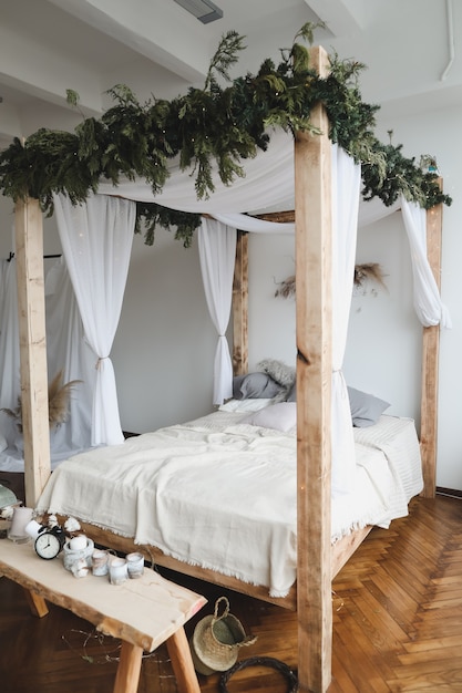 intérieur de chambre moderne de style scandinave avec un lit confortable avec baldaquin en bois et oreillers